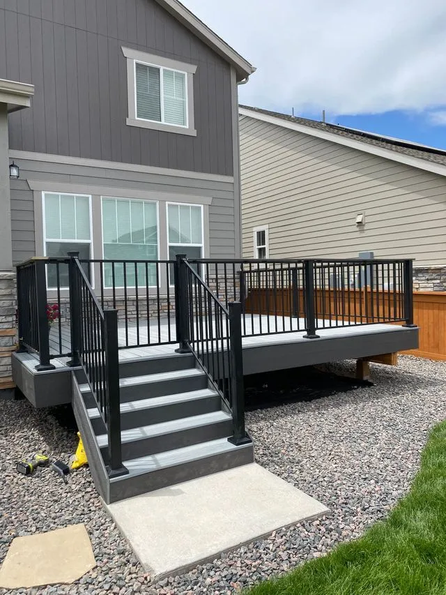 Composite deck with stairs and backyard landscaping